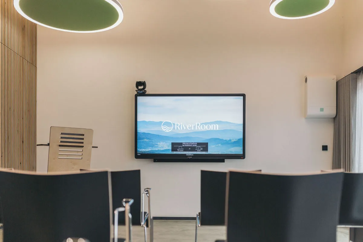 75 Zoll OLED TV mit RiverRoom-Logo, daneben das Rednerpult